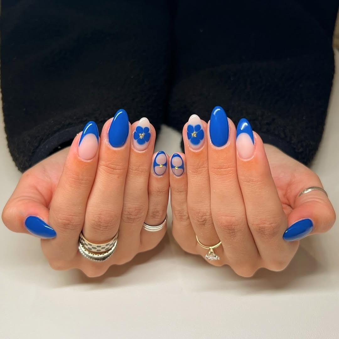 Vibrant blue nails with floral accents