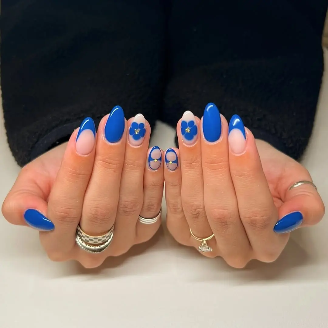 Vibrant blue nails with floral accents