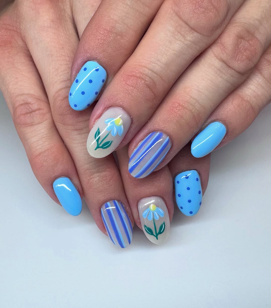 Vibrant blue nails with floral accents
