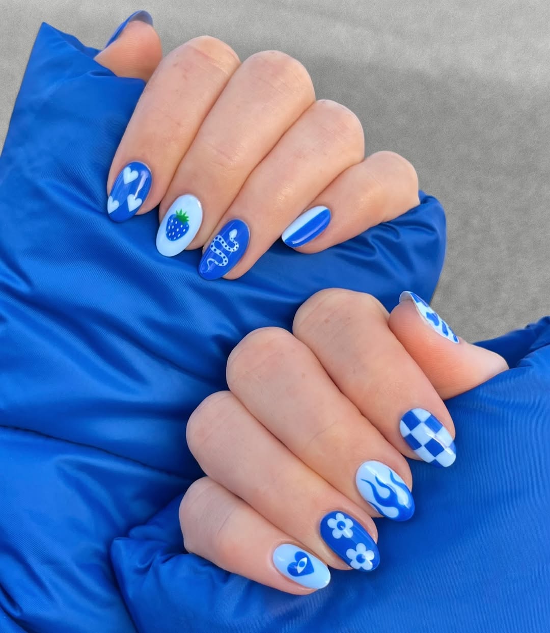 Vibrant blue nails with playful designs.