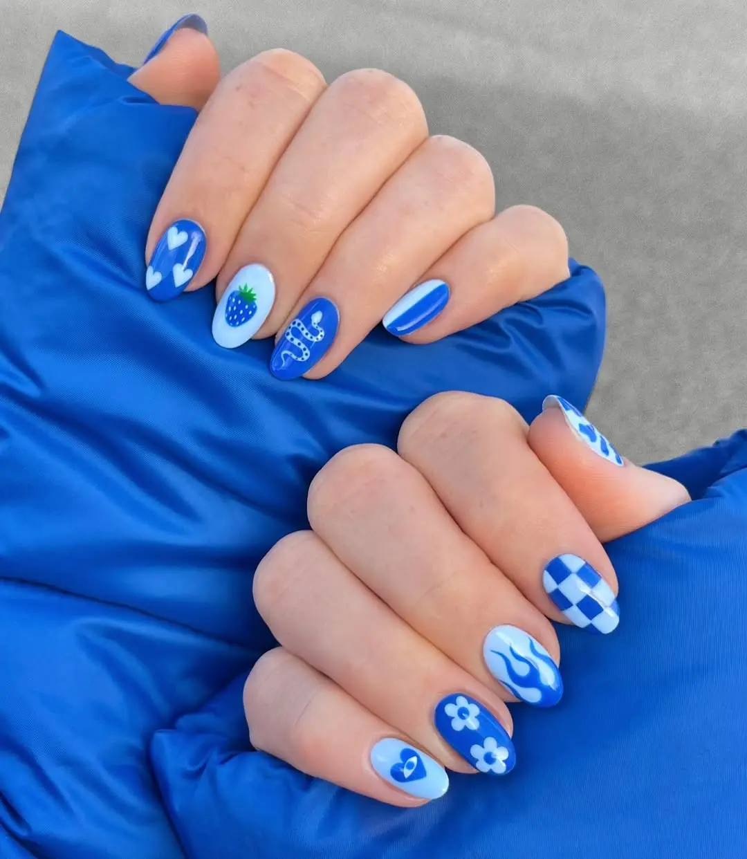 Vibrant blue nails with playful designs.