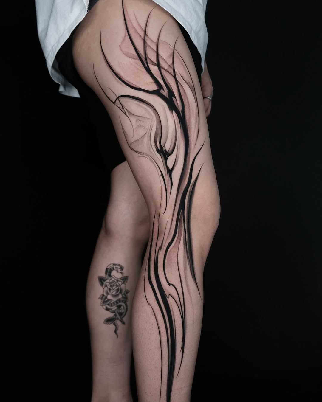 Striking black line tattoo on the thigh
