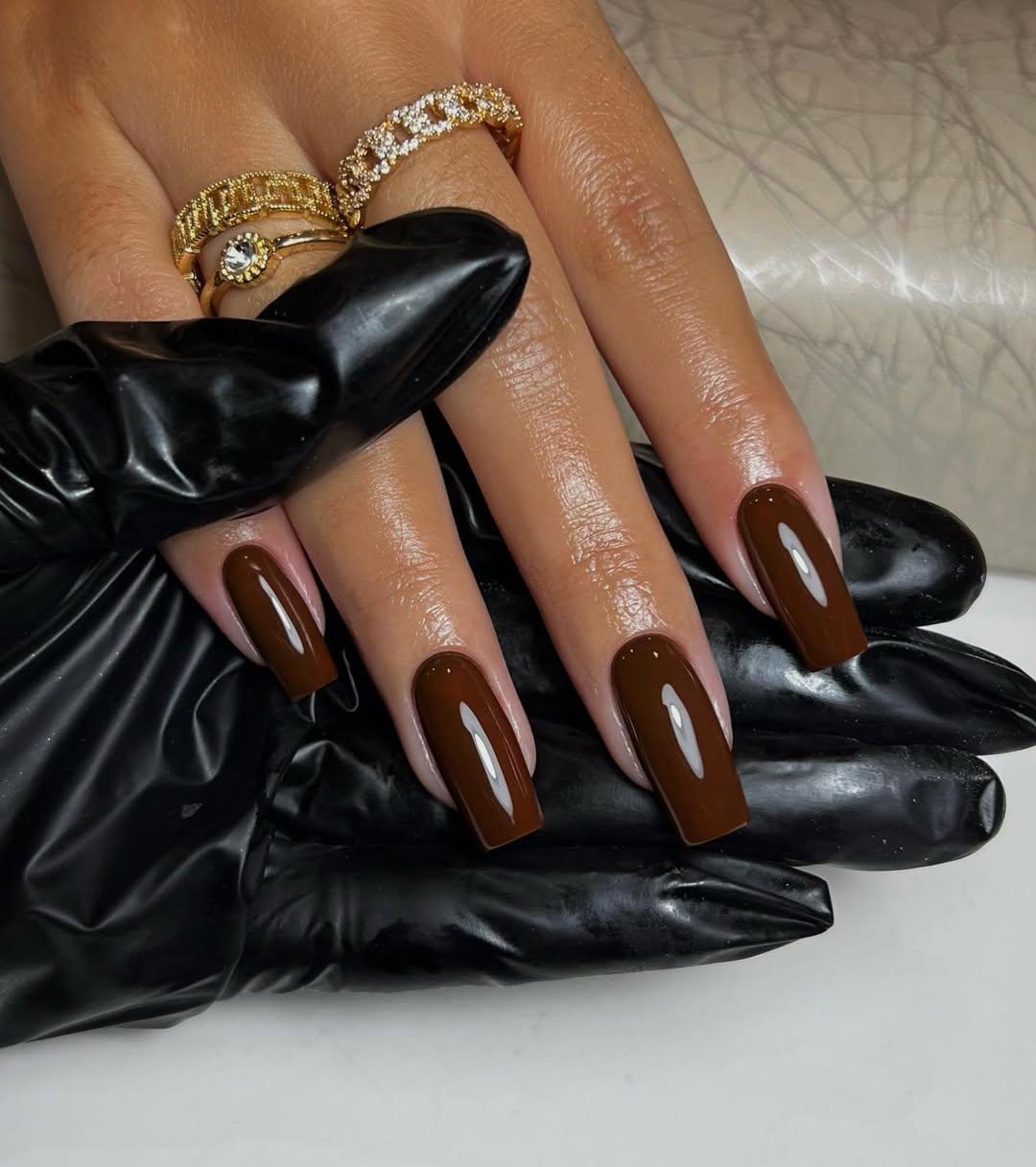 Stylish glossy brown nails with elegant rings