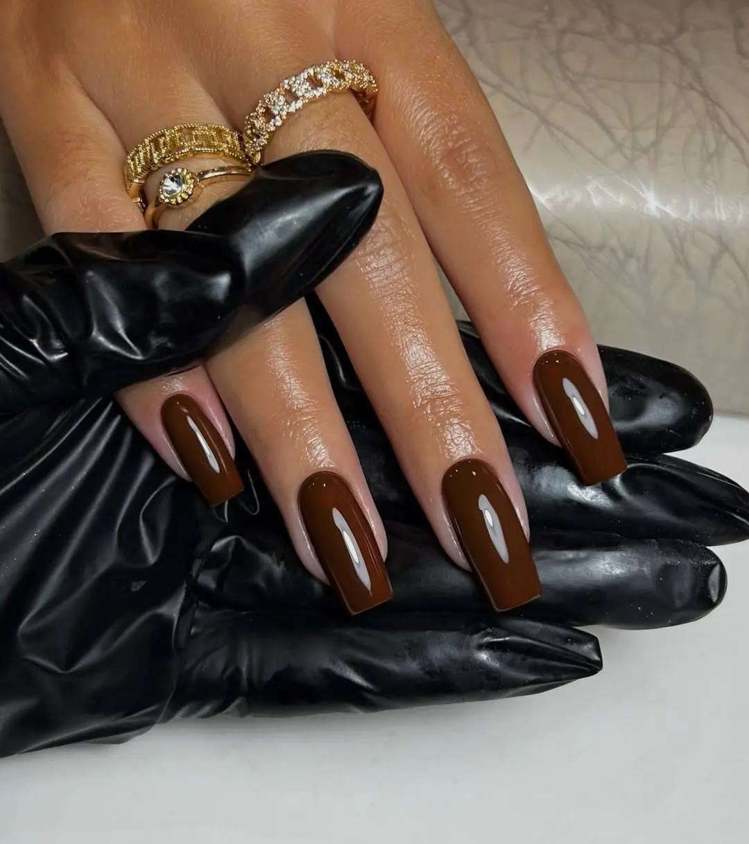Stylish glossy brown nails with elegant rings