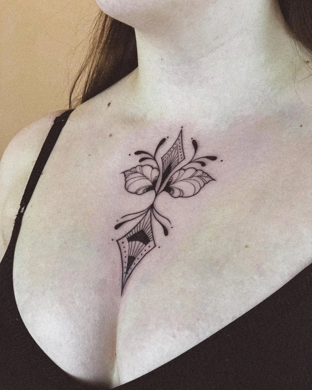 Elegant butterfly tattoo gracing the chest.