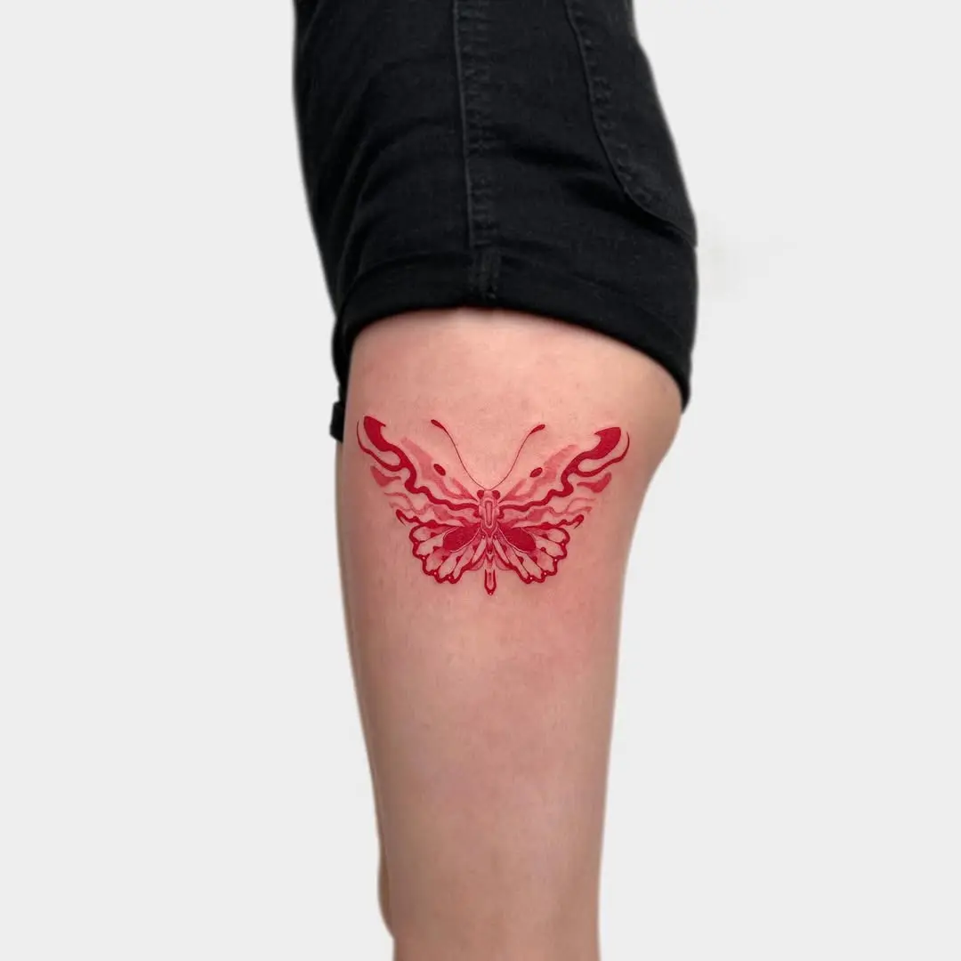 Stunning butterfly thigh tattoo with fiery details