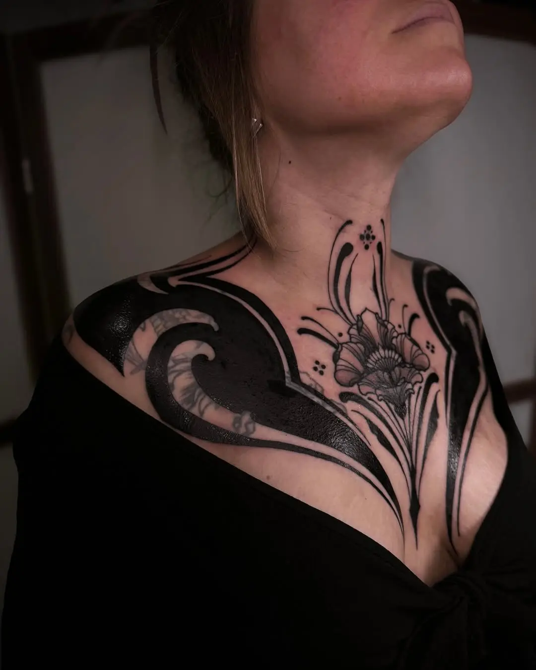 Elegant black floral chest tattoo design