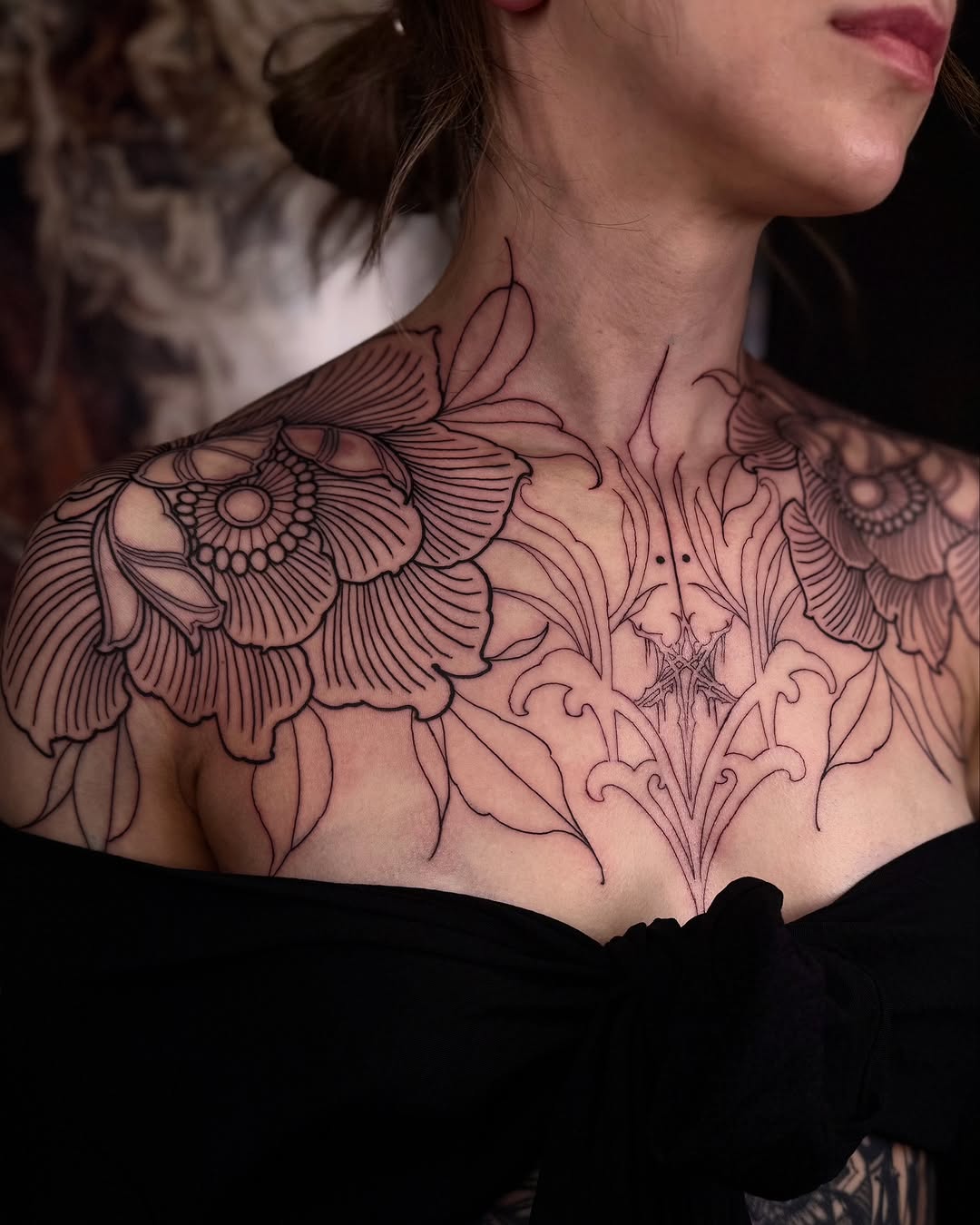 Elegant floral chest tattoo with bold outlines