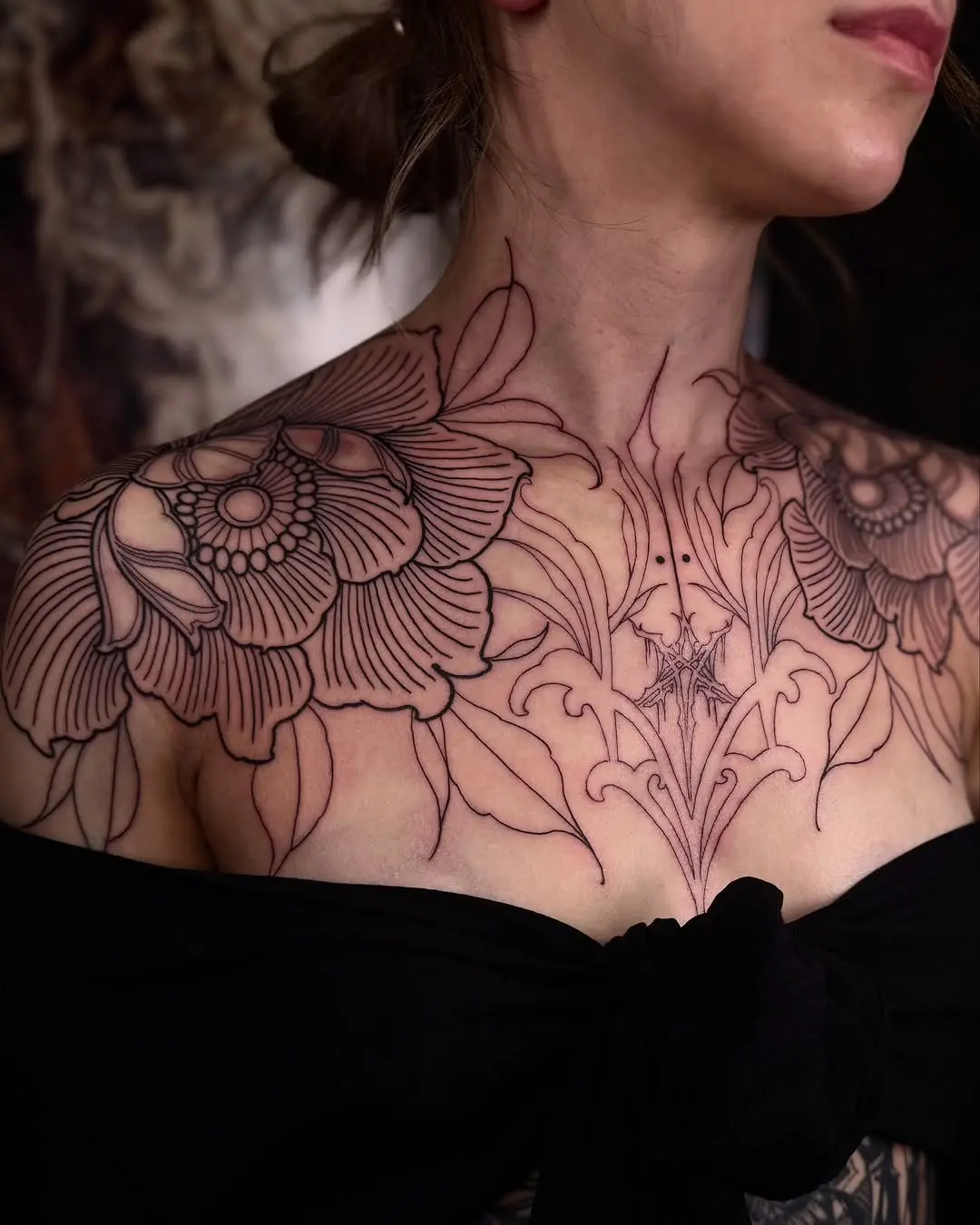 Elegant floral chest tattoo with bold outlines