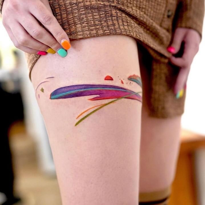 Vibrant abstract thigh tattoo in bold colors