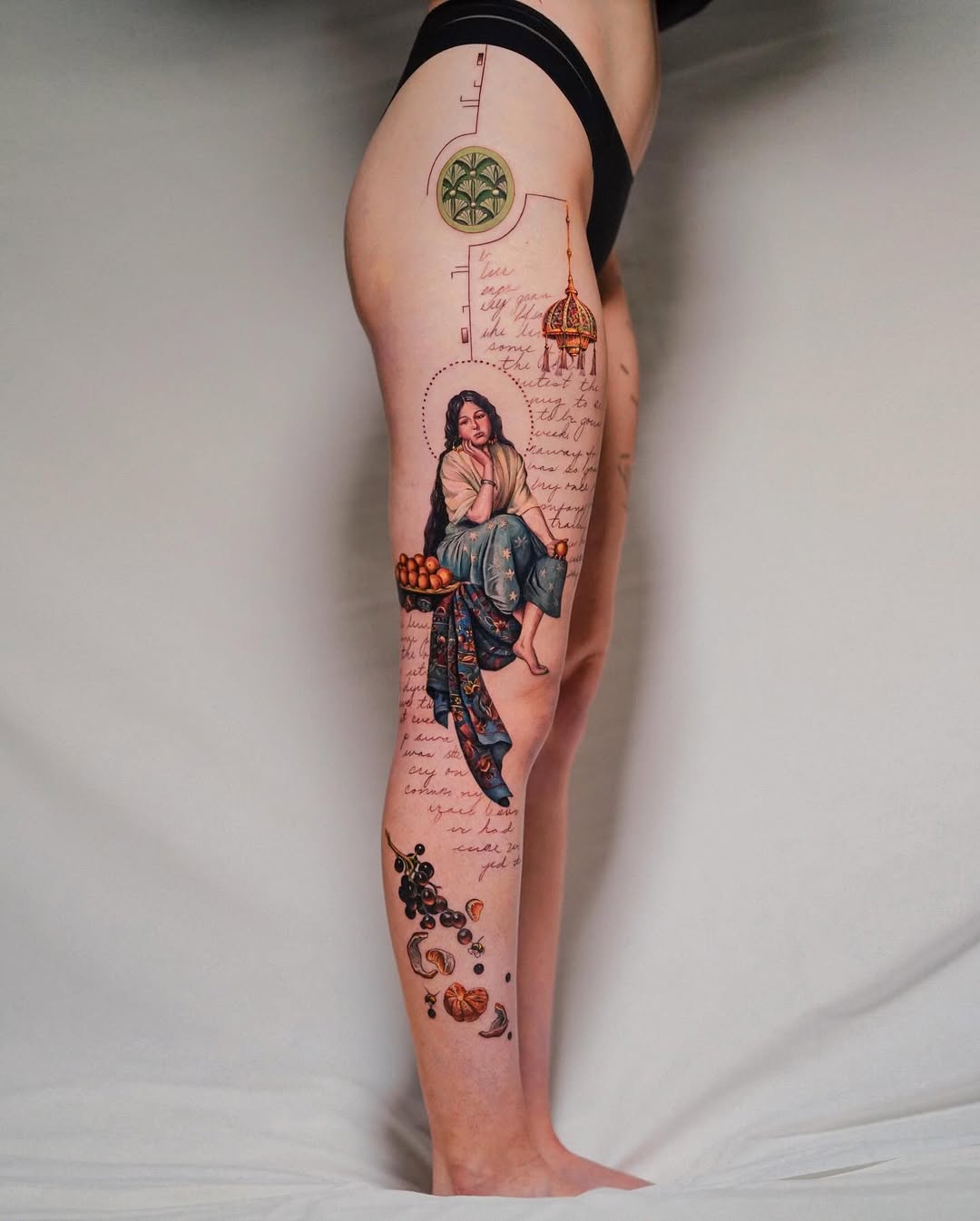 Intricate leg tattoo featuring a seated woman