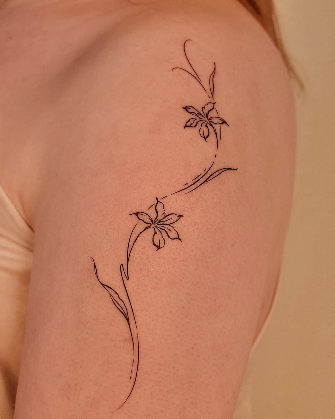Elegant floral fine line tattoo on the arm