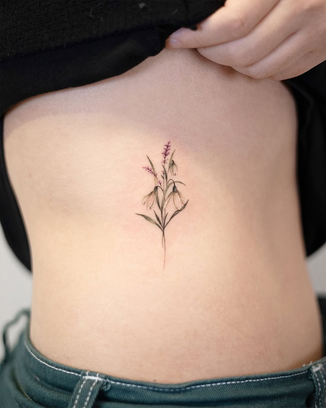 Delicate flower tattoo on rib cage