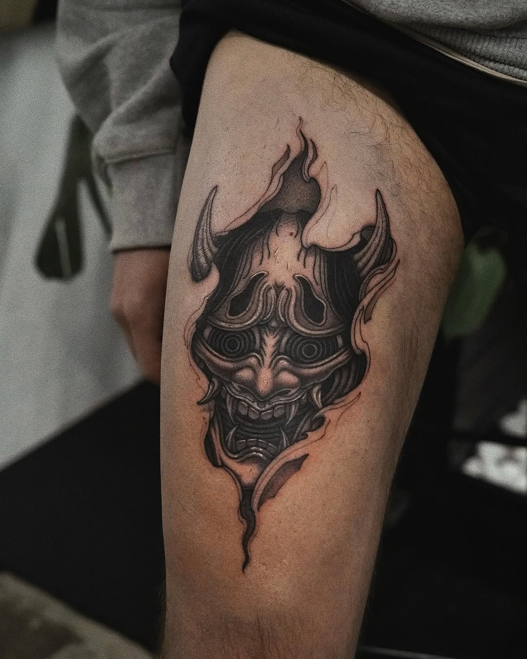 Intricate Demonic Mask Tattoo on Thigh