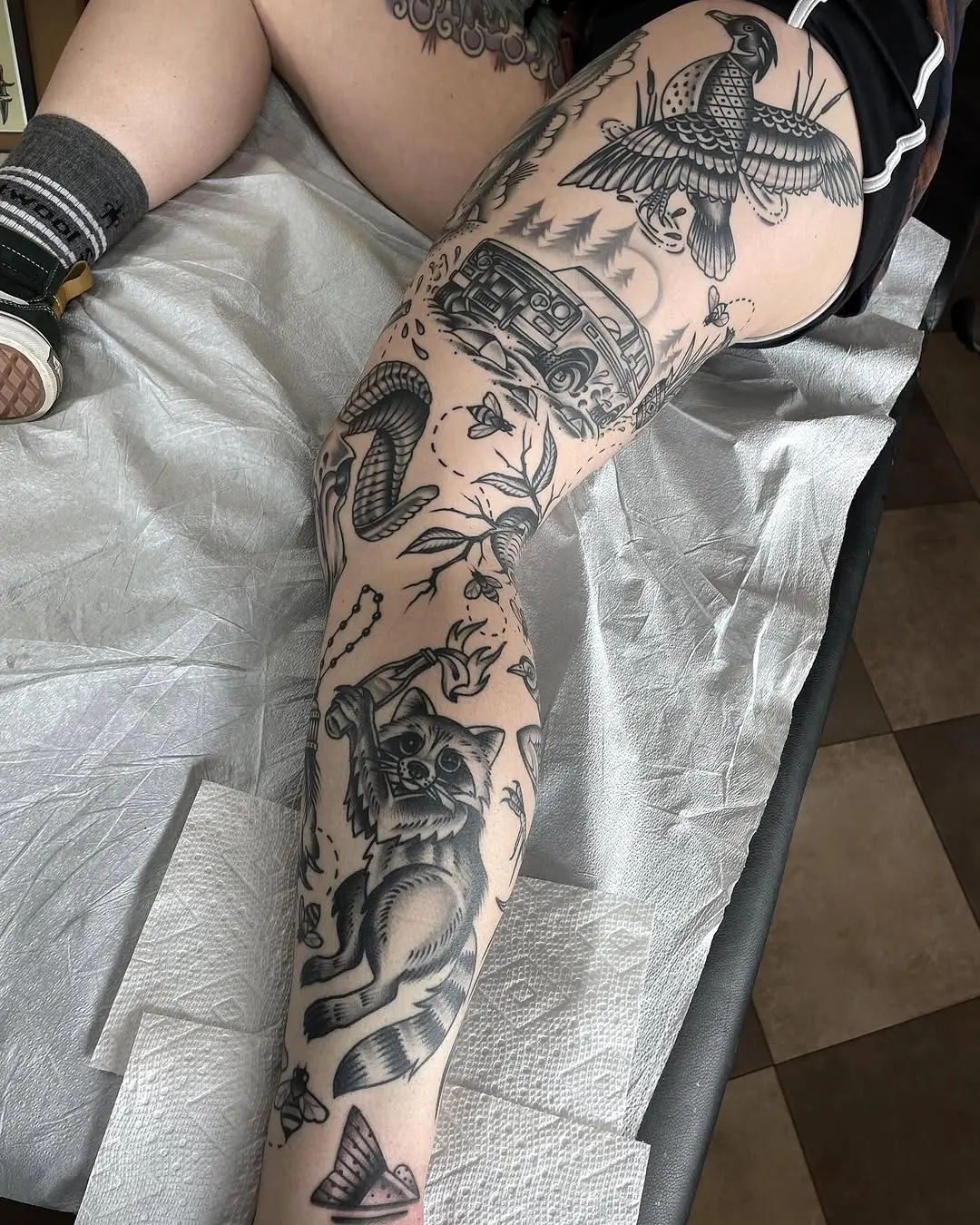 Intricate leg tattoos featuring animals and nature