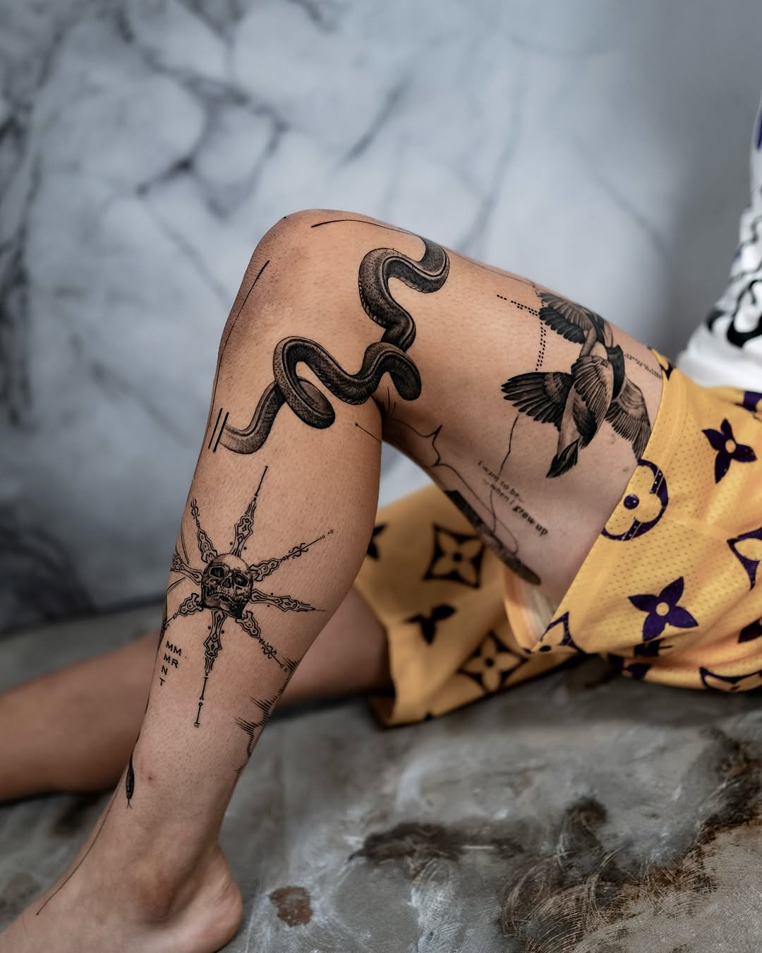 Intricate leg tattoos featuring nature and symbols