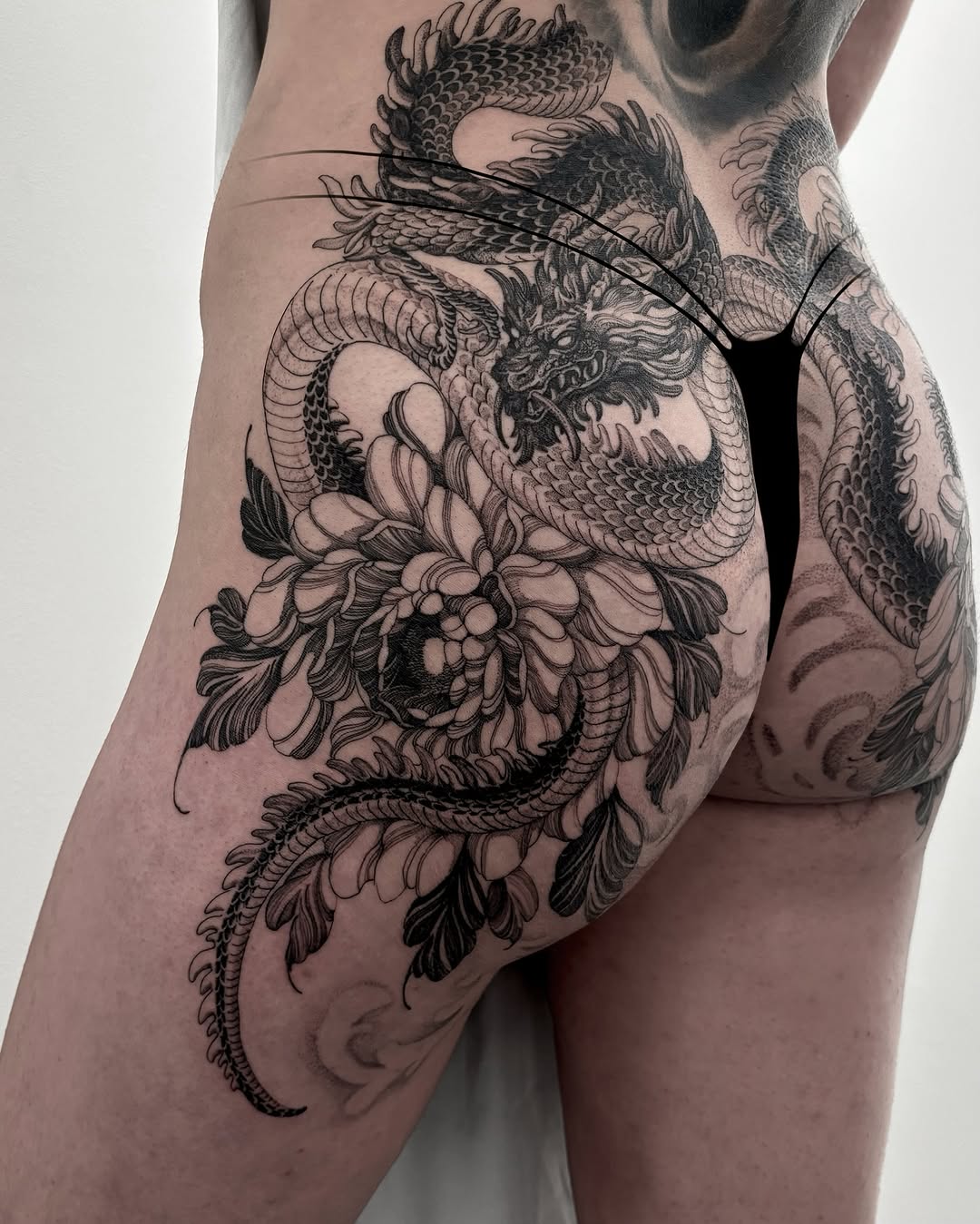 Stunning dragon and flower thigh tattoo design