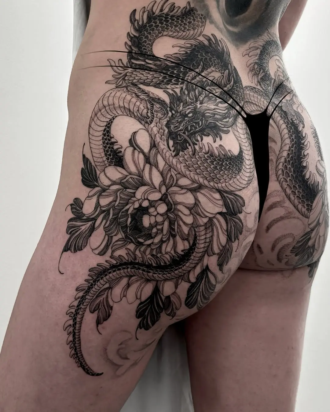 Stunning dragon and flower thigh tattoo design