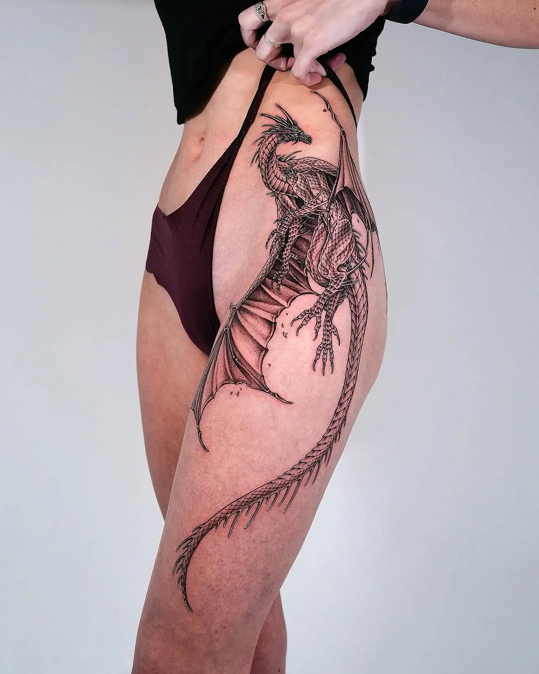 Striking dragon thigh tattoo in intricate detail