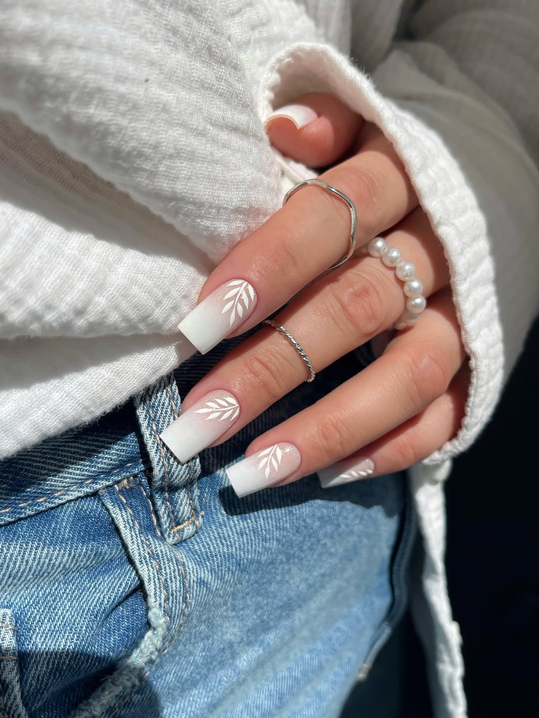 Elegant white nails with delicate leaf design