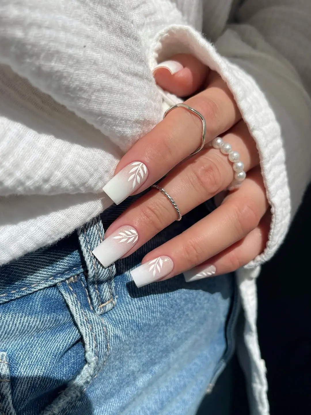 Elegant white nails with delicate leaf design