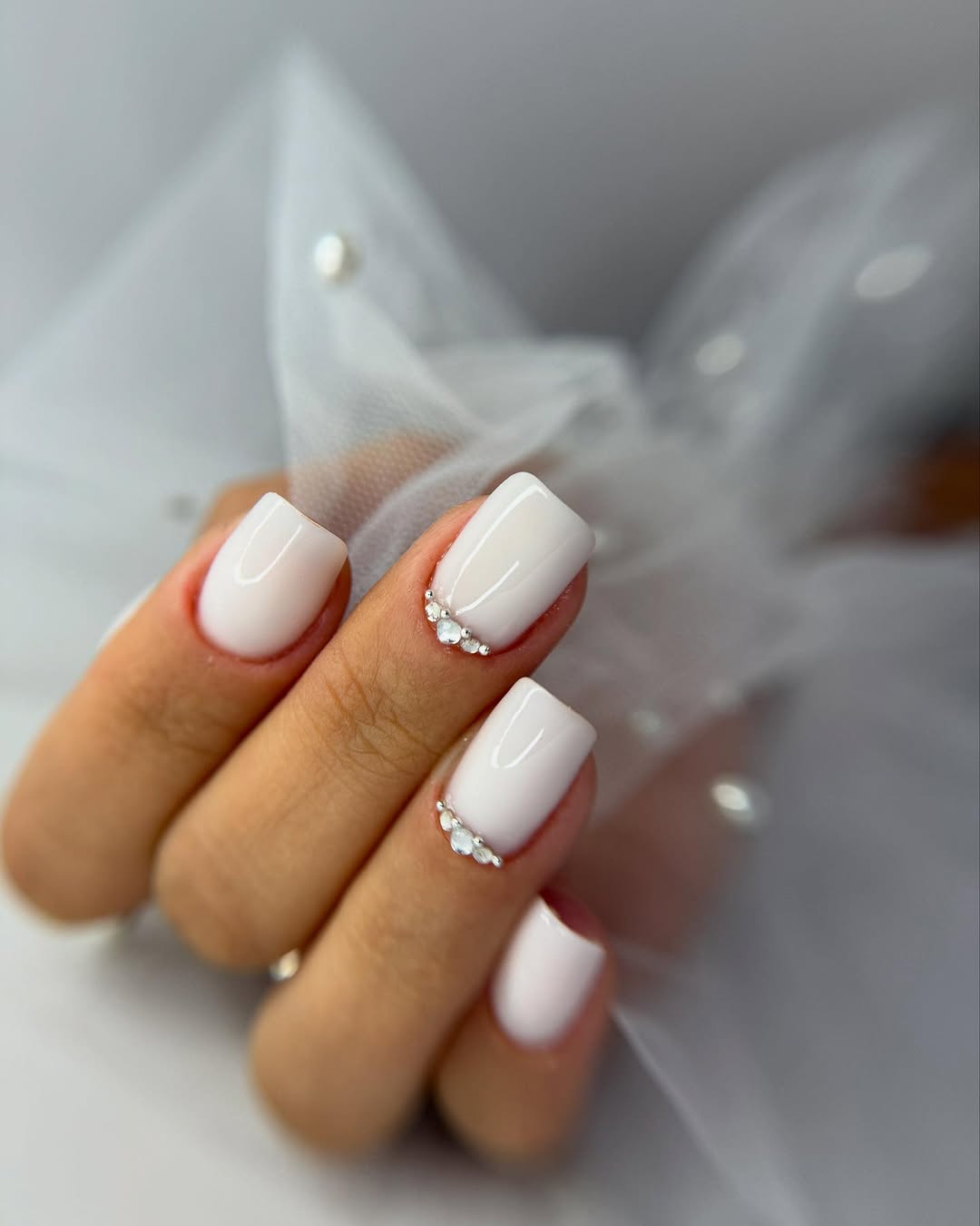 Chic white nails adorned with rhinestones