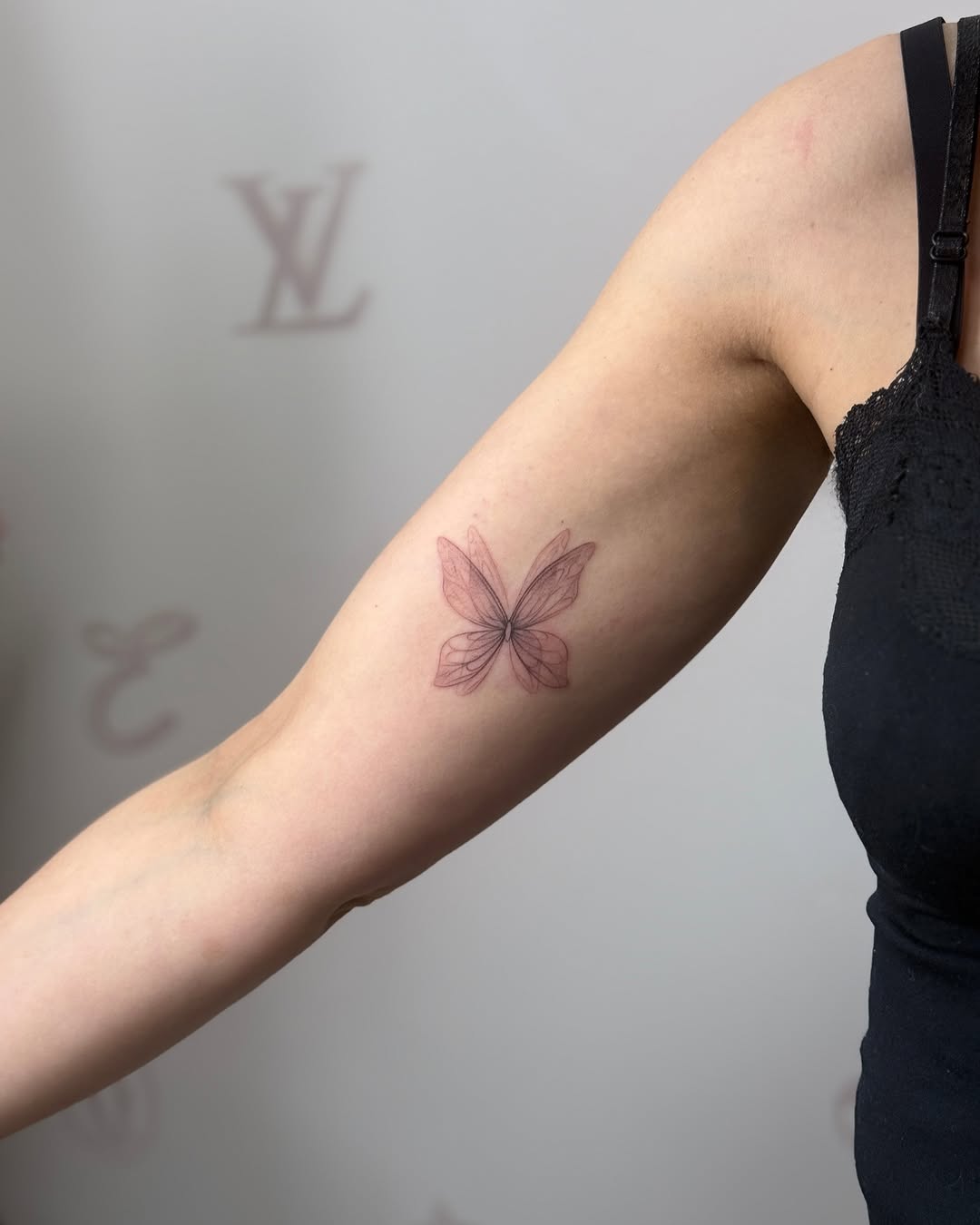 Graceful fine line butterfly tattoo on arm
