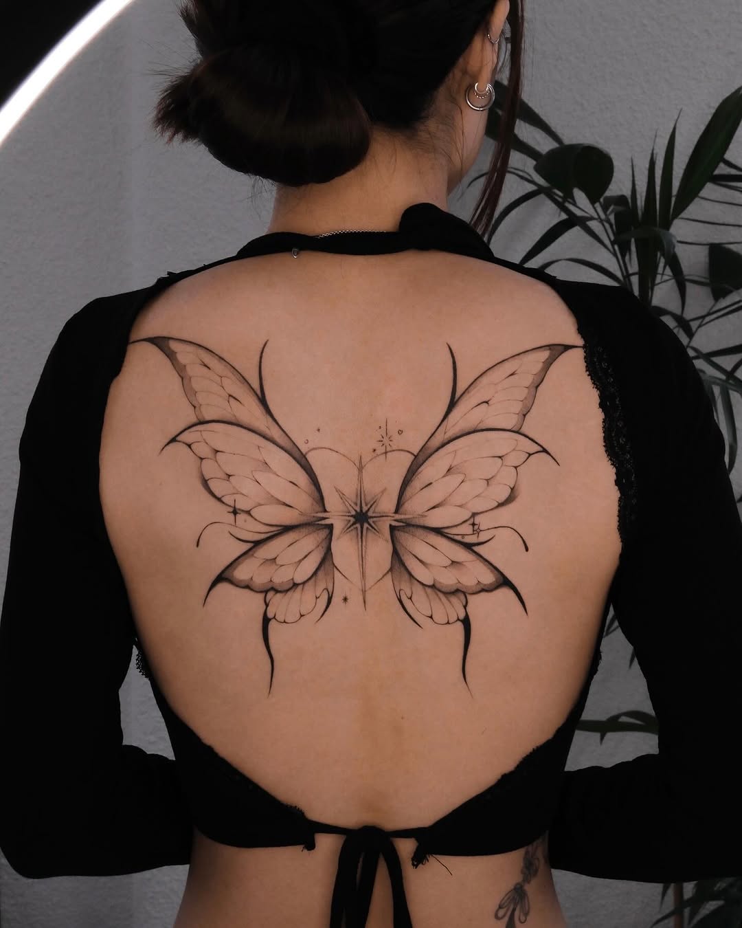 Delicate butterfly fine line tattoo on back