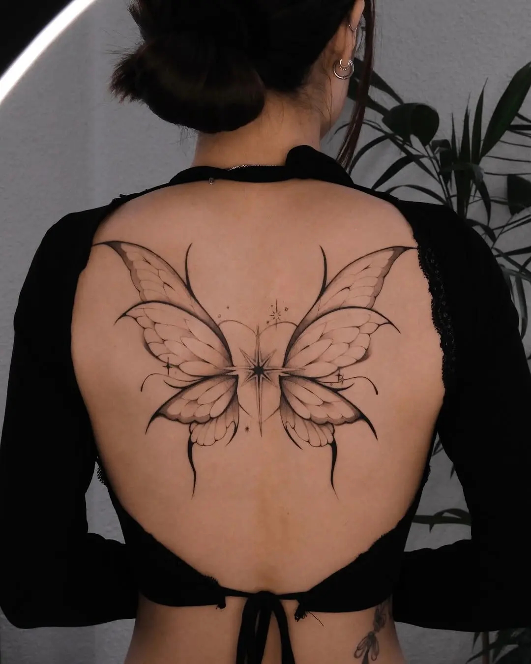 Delicate butterfly fine line tattoo on back