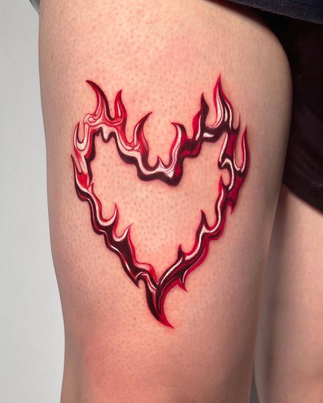 Eye-catching flame heart leg tattoo design