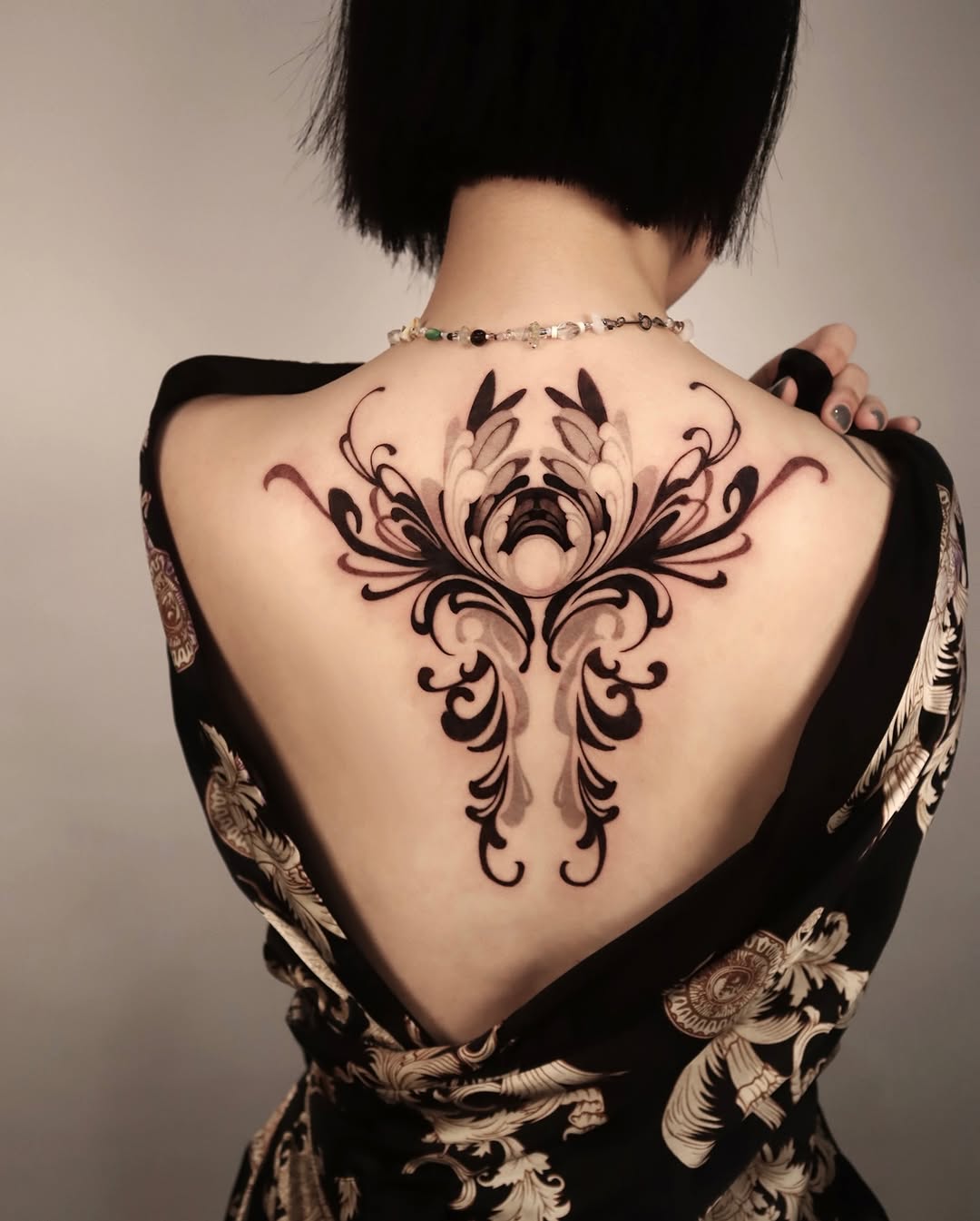 Elegant floral back tattoo in rich black ink