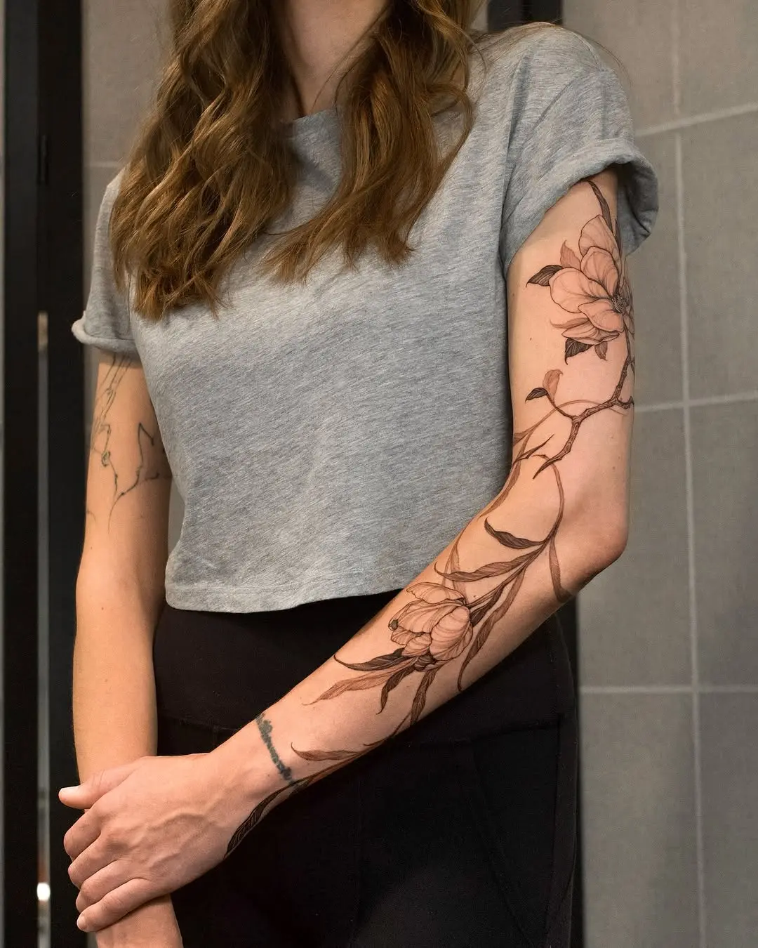 Elegant magnolia flower tattoo on the arm