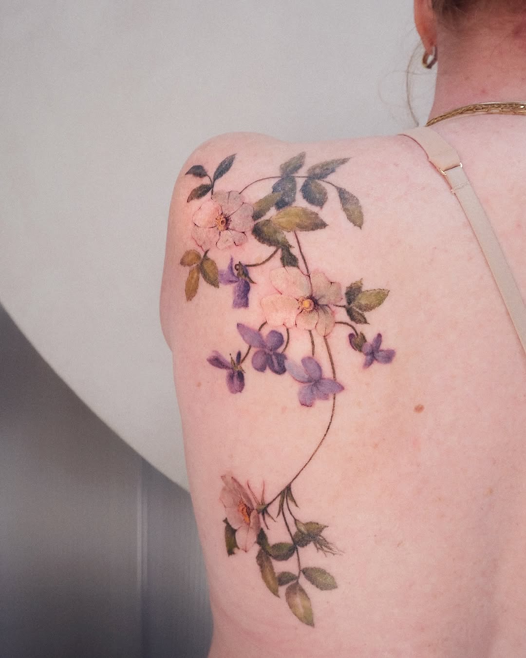 Delicate floral back tattoo with soft colors