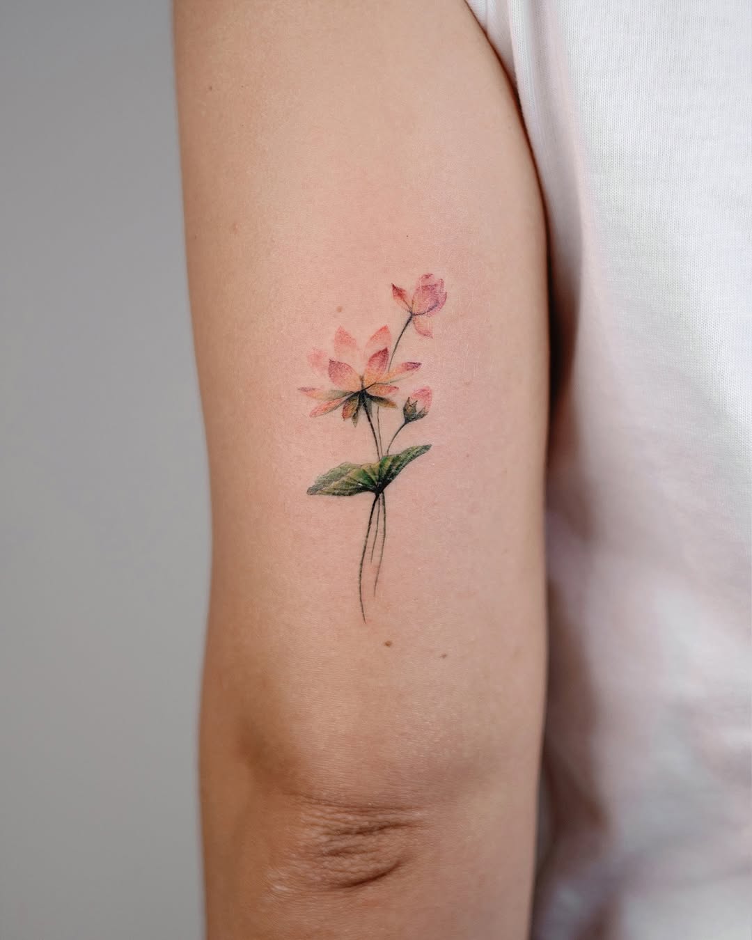 Delicate watercolor rose tattoo on arm
