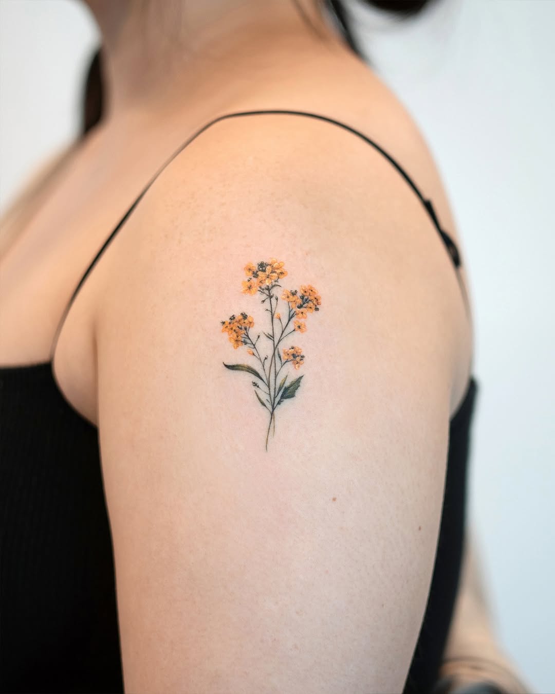 Delicate shoulder flower tattoo with vibrant colors
