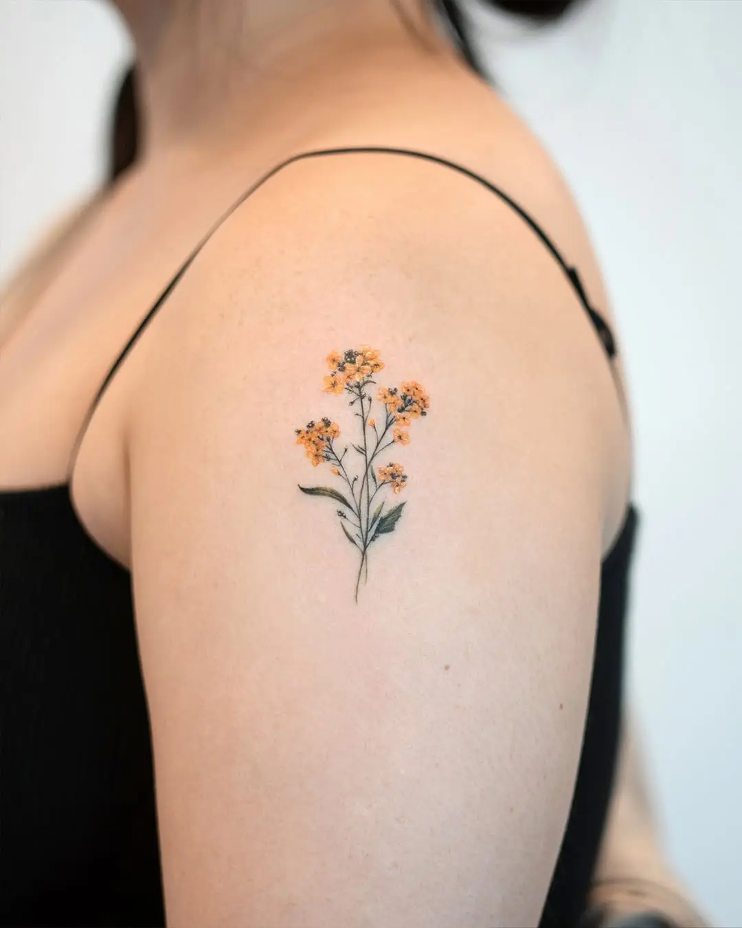 Delicate shoulder flower tattoo with vibrant colors