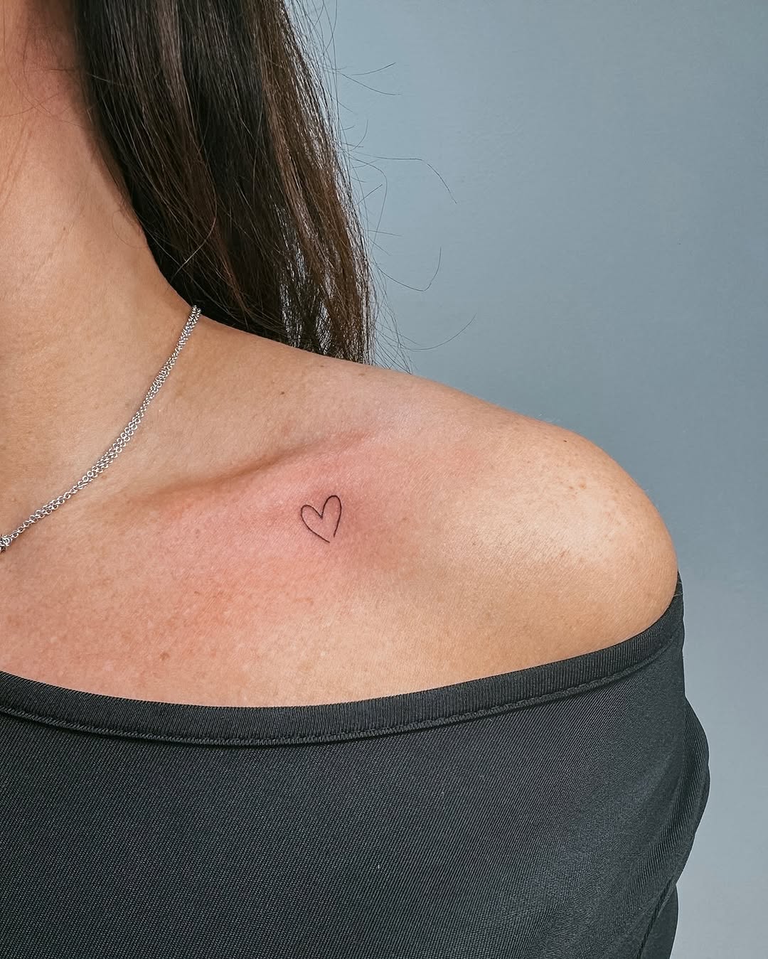 Delicate heart tattoo on shoulder area