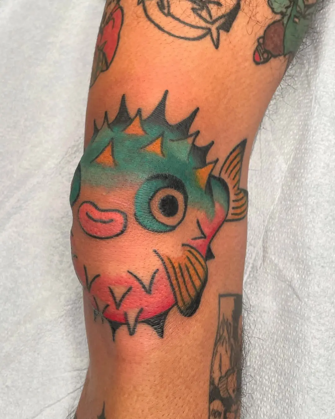 Colorful pufferfish knee tattoo design inspiration