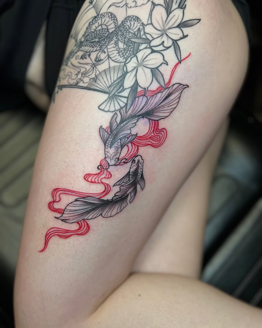 Vibrant koi fish tattoo adding elegance to thigh