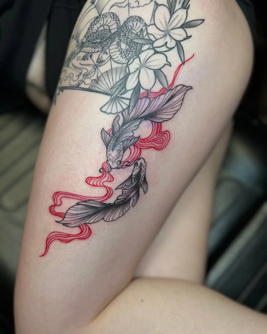 Vibrant koi fish tattoo adding elegance to thigh