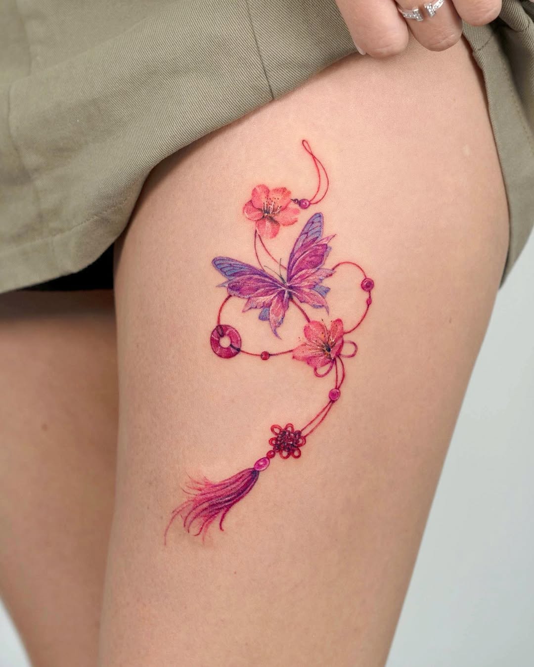 Elegant butterfly and floral thigh tattoo design