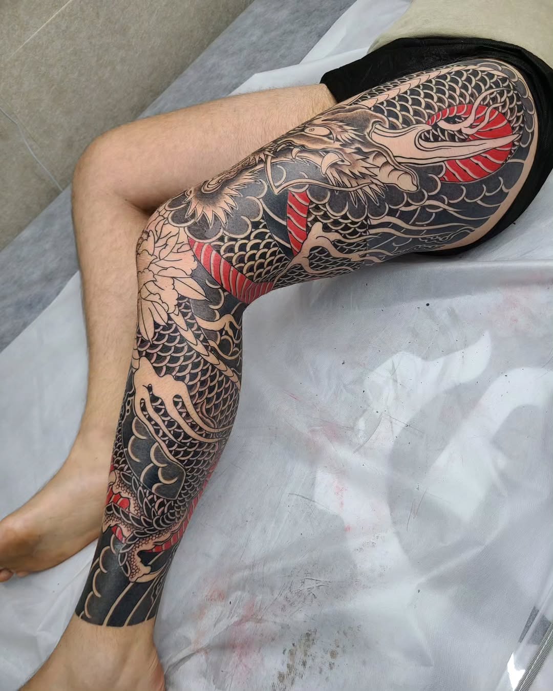 Intricate dragon tattoo with vibrant red accents