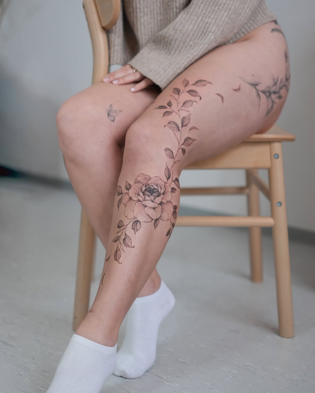 Elegant floral leg tattoo with flowing leaves
