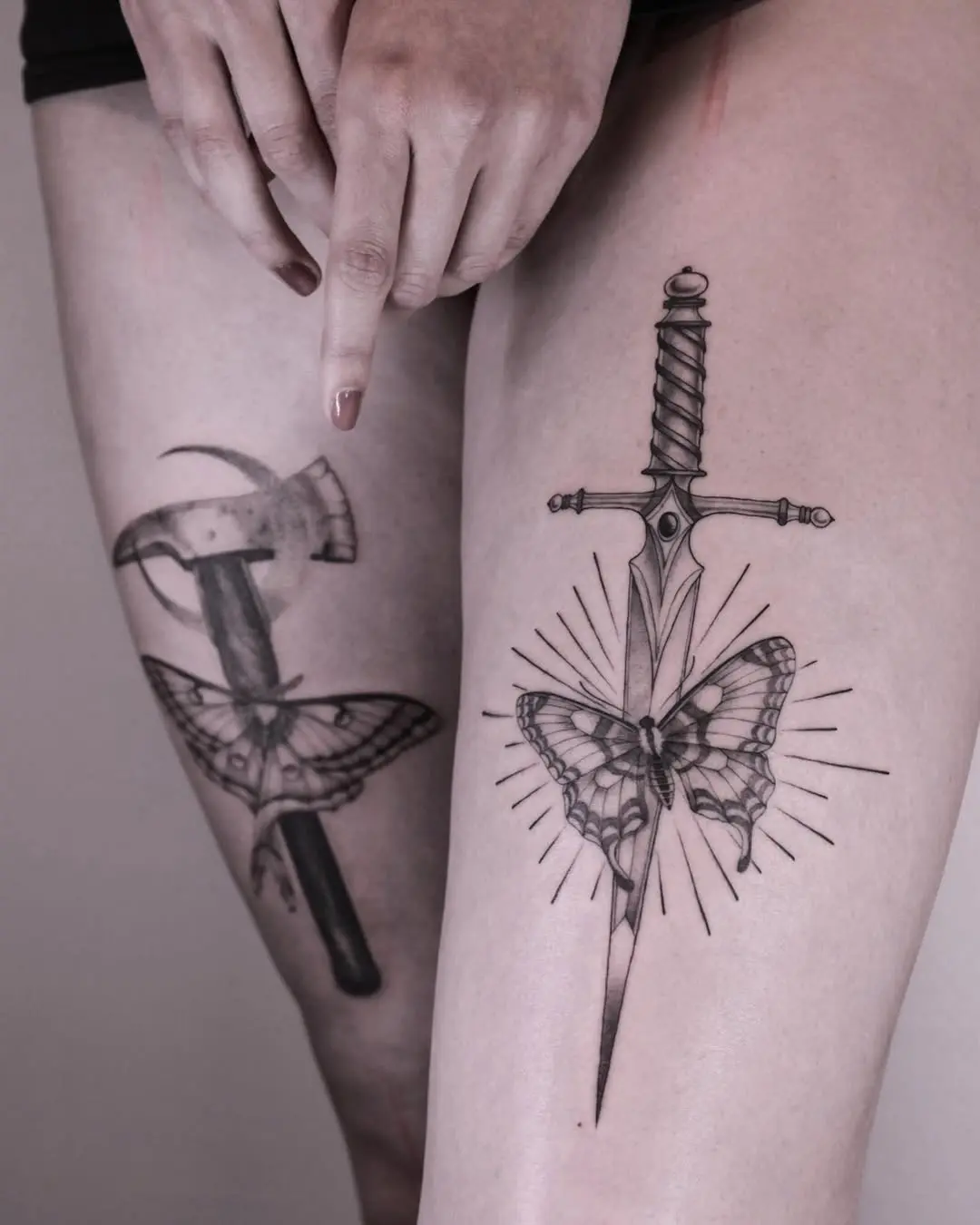 Intricate leg tattoos blending nature and weaponry