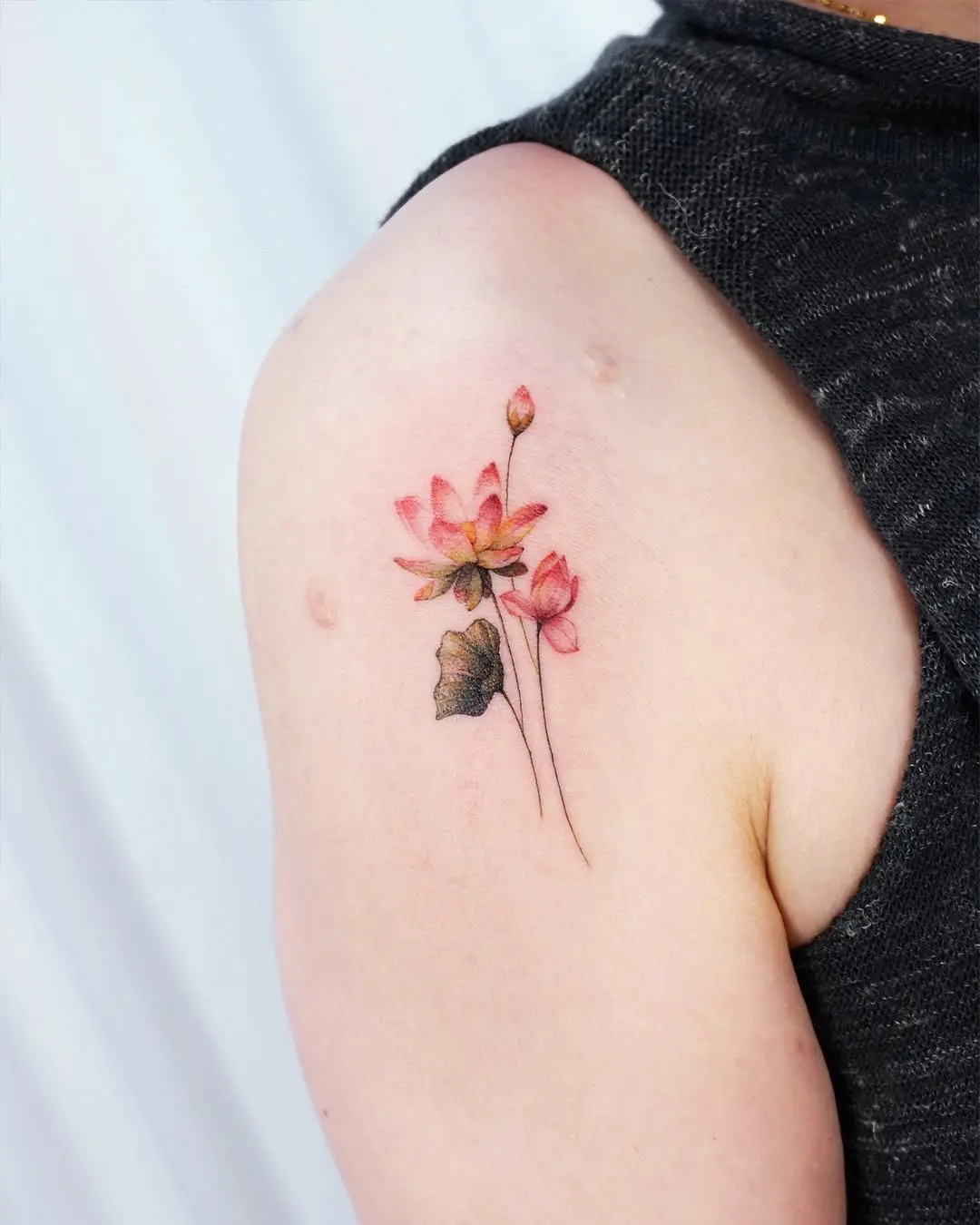 Delicate lotus flower tattoo on the arm