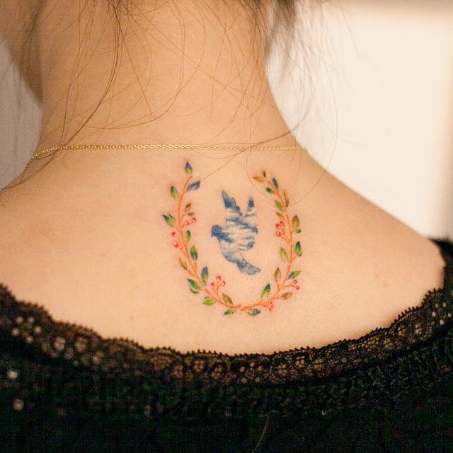 Delicate dove tattoo embraced by floral artwork