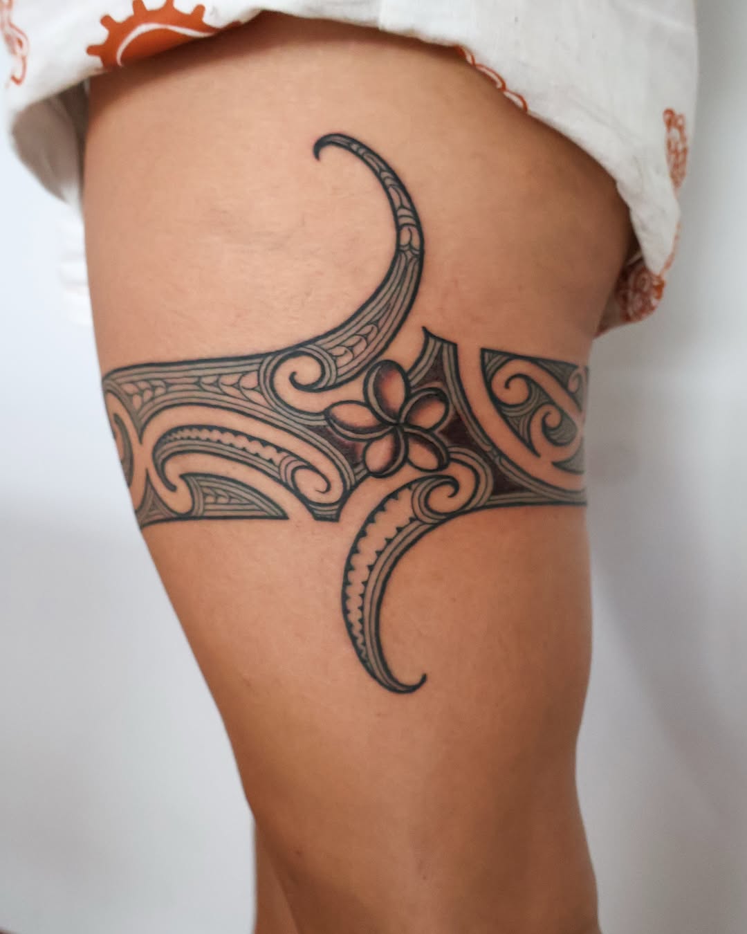 Intricate Maori-inspired thigh tattoo design