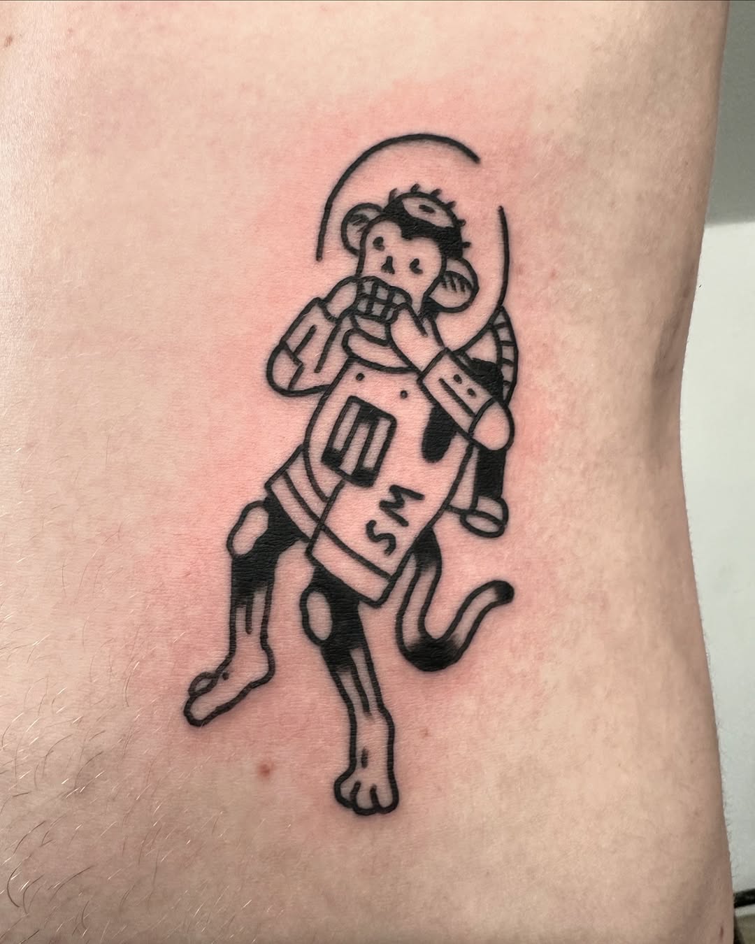 Playful astronaut monkey tattoo showcasing creativity
