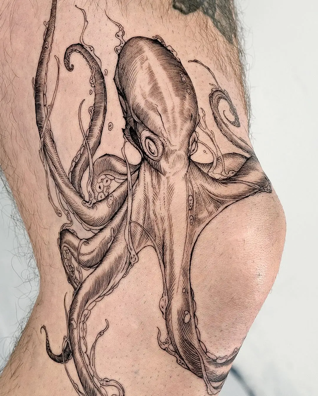 Intricate octopus tattoo wrapped around the thigh