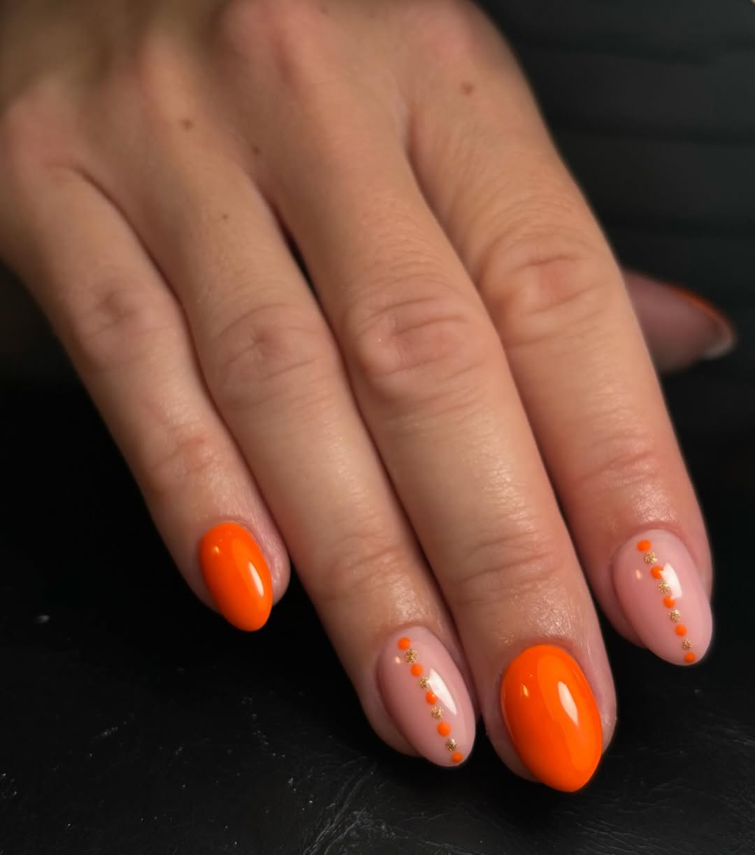Vibrant orange nails with chic detailing